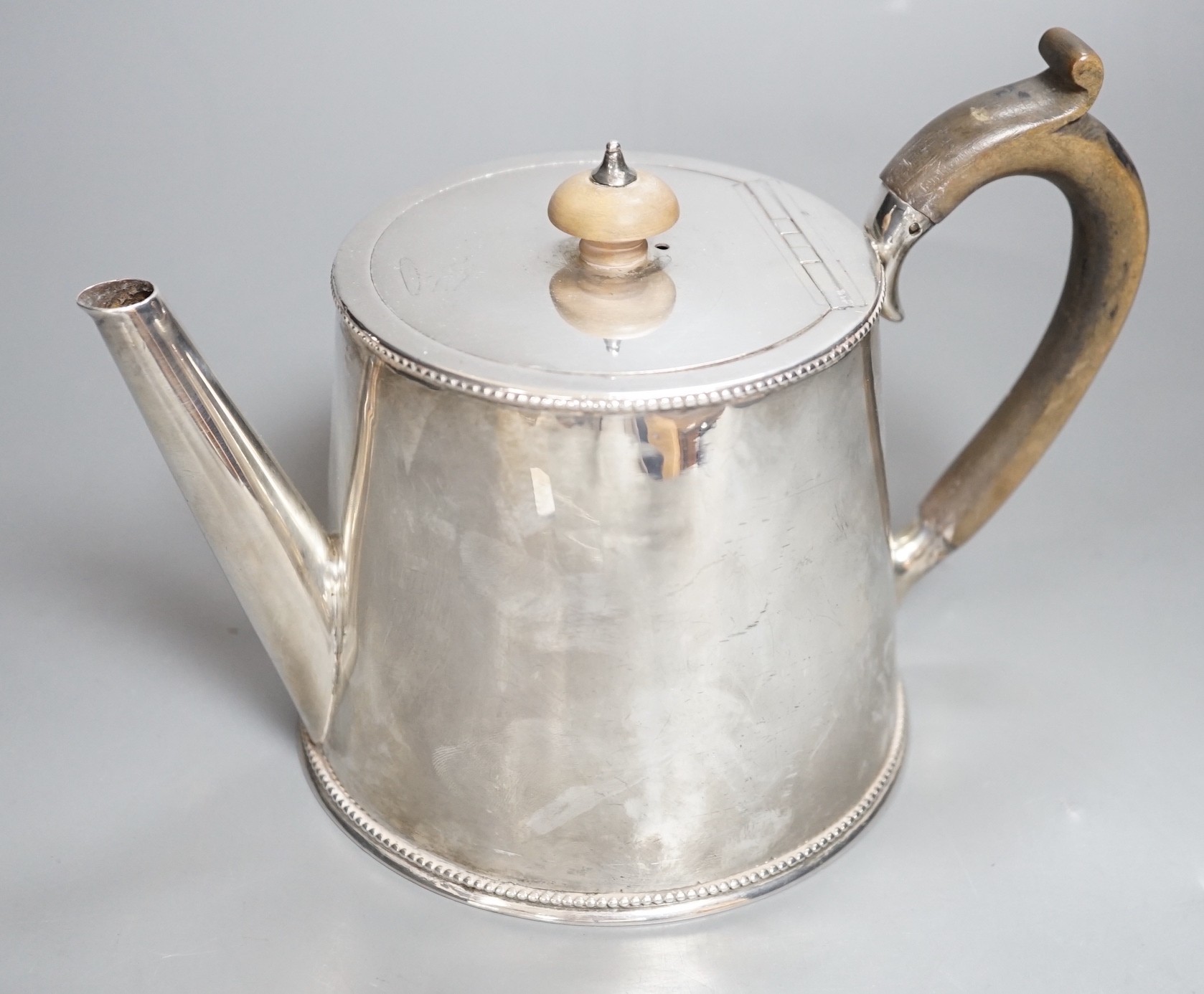 A late Victorian silver teapot, of cylindrical tapering form, William Comyns, London, 1883, gross 15oz.